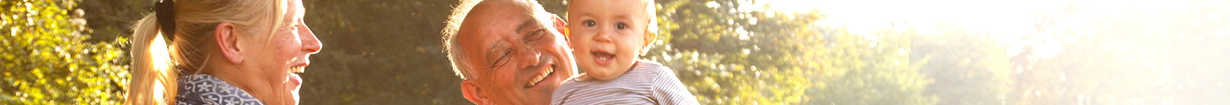 headshots on summers day of smiling family, woman, man and baby