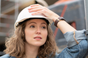Young female worker wearing a white hard hat