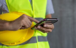 construction worker hands touch screen using smartphone - protect your super from scams